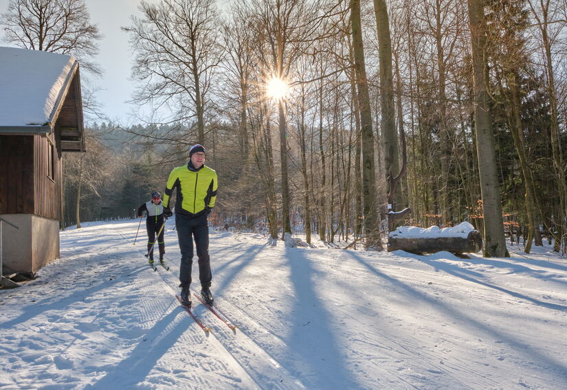 Zwei Skifahrer bei sonnigem Winterwetter unterwegs auf der Kalte-Heide-Loipe in Brotterode